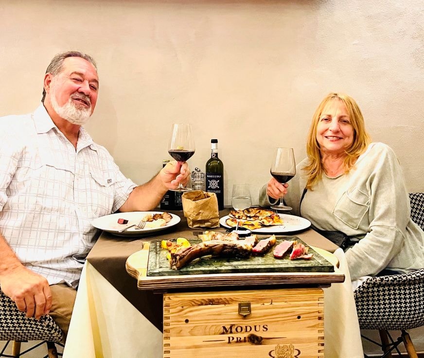 Couple toasting wine at steak dinner Florence