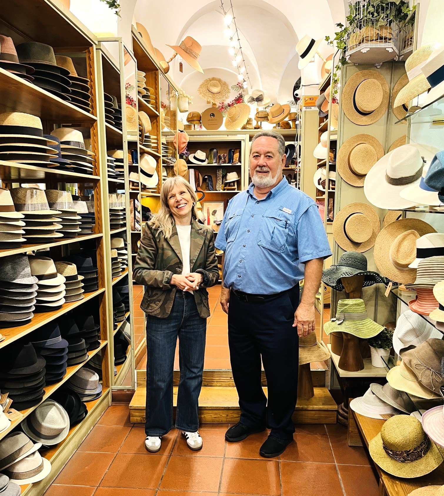 Two people in hat shop surrounded by hats Siena