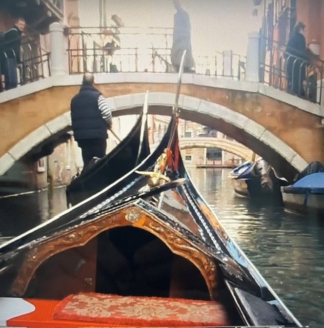 Gondola passing under Venetian bridge canal